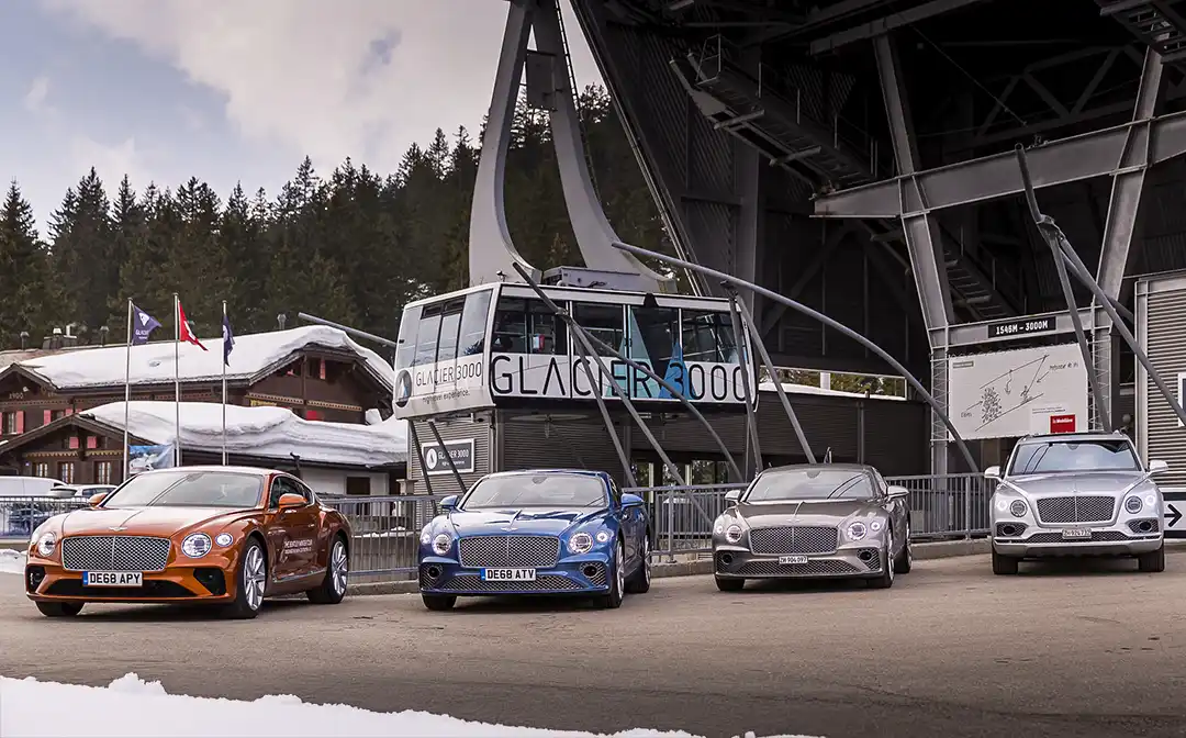 Continental GT orange avec hélicoptère au Bentley Winter Tour 2019 à Gstaad 